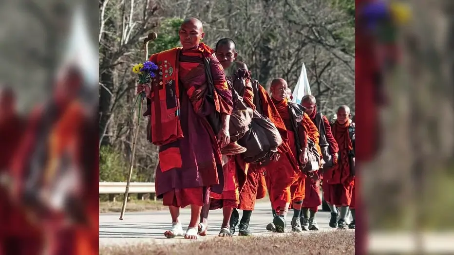 “Buddhist monks walking in harsh conditions under strong sunlight during the Walk for Peace, symbolizing endurance, spiritual strength, and peace.”