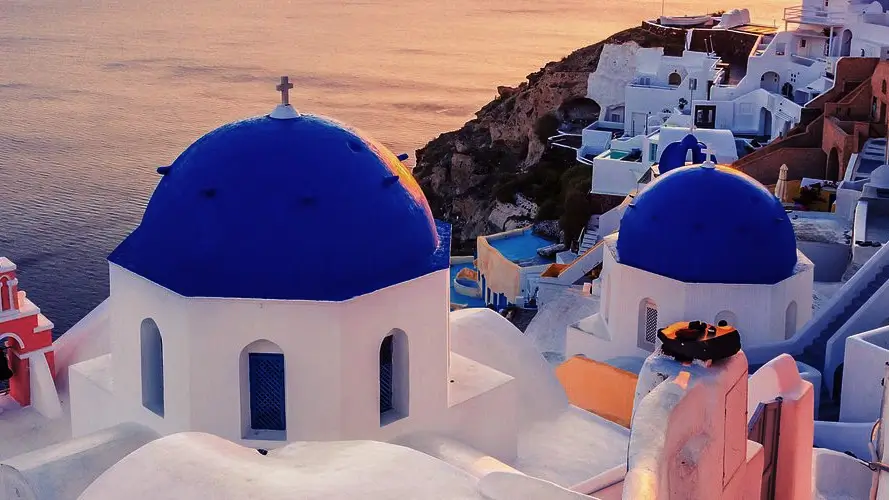 The whitewashed buildings with bright blue domes perched 