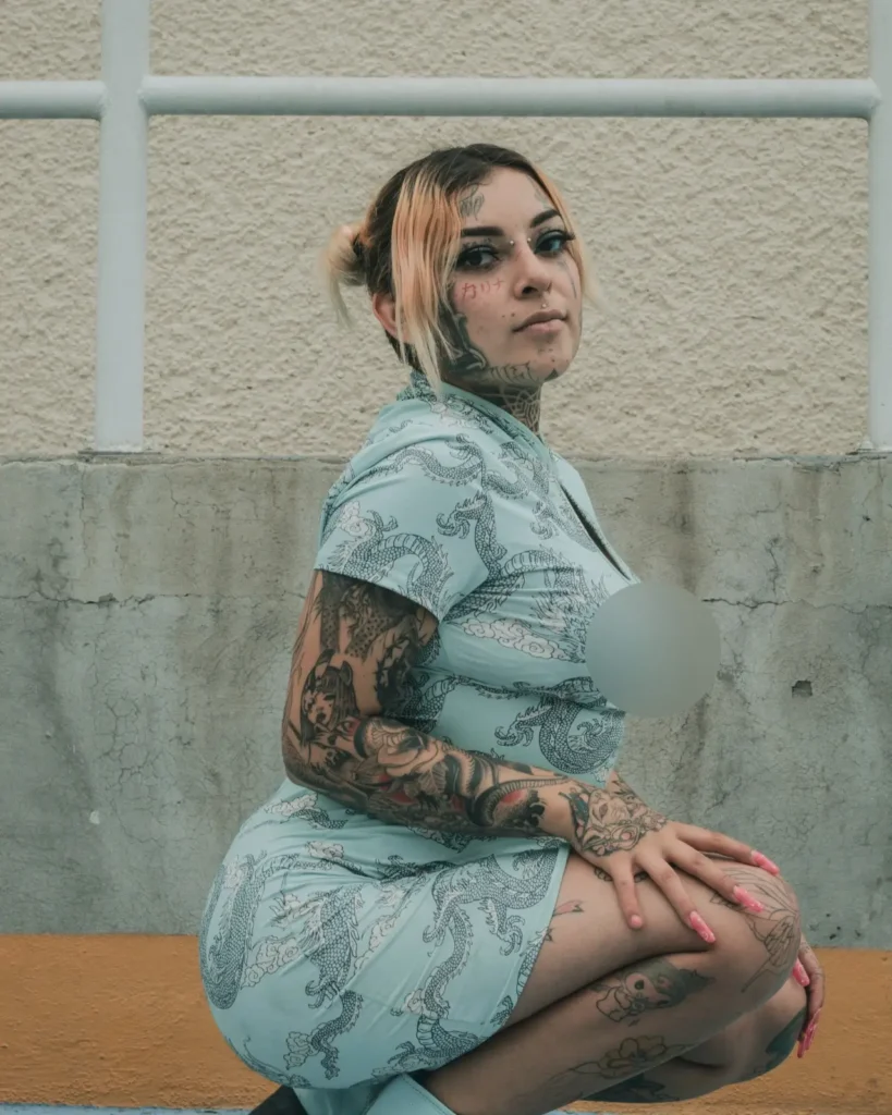 woman showing butterfly tattoo on upper arm