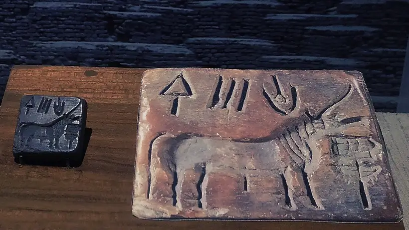 Indus Valley stone seal showing a one-horned bovine with head raised over an altar-like object